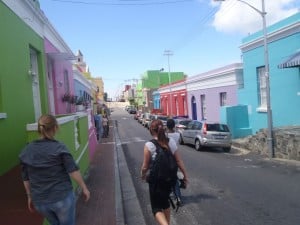 A group of people walking through a colourful Cape Town neighbourhood