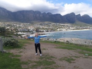 Lady standing with arms outstretched on Cape Town coastline