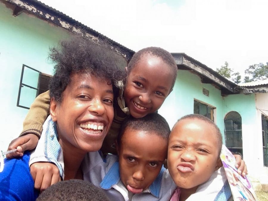 Naila and kids from an orphanage smiling and pulling silly faces