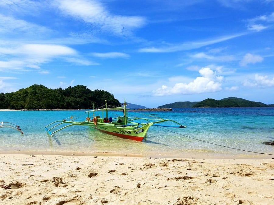 A boat on the water on a beach in the Phillippines