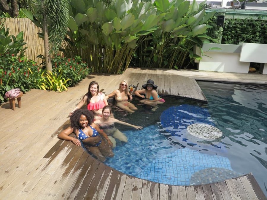 Travellers sitting in a pool with drinks