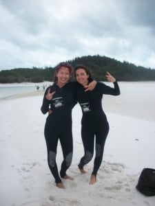 Pippa Yeates and a fellow traveller in wetsuits on the beach