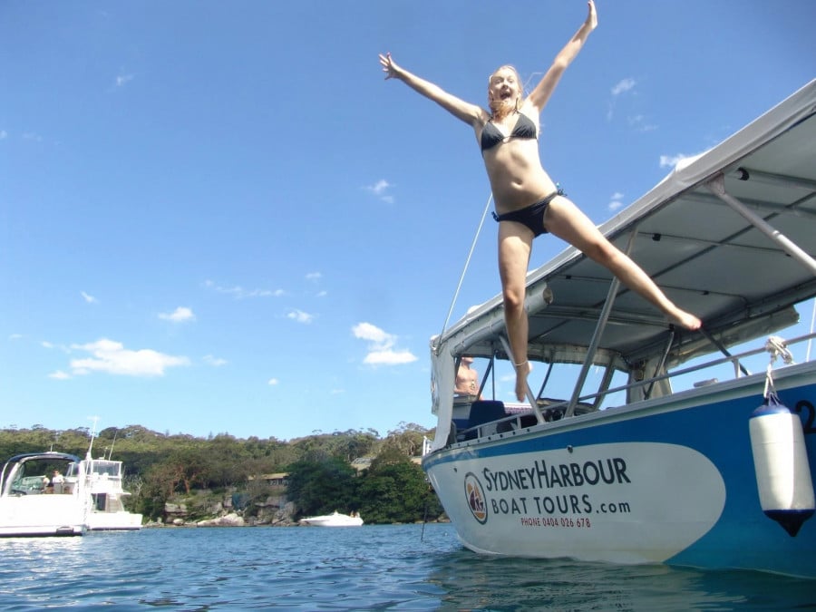 Girl jumping from a boat into water in Sydney Harbour