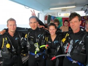 Divers aboard a boat posing for a photo