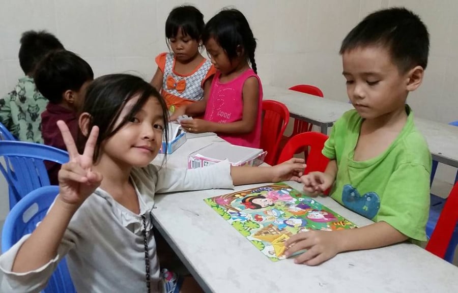 Kids sitting in a classroom doing puzzles