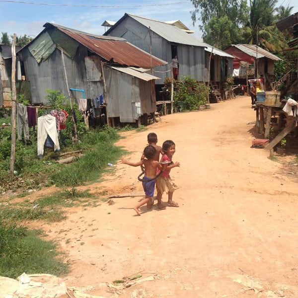 Kids in Cambodia playing on a dirt road in a village