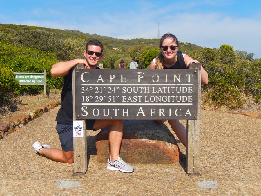 Two people posing next to a sign for Cape Point, South Africa