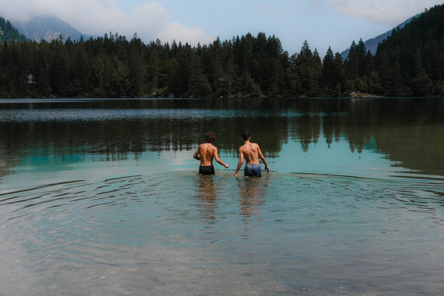Travellers wild swimming in Ville d'Anaunia, Italy 
