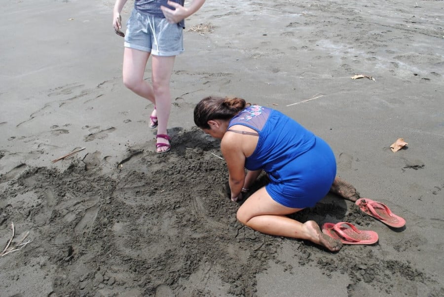 A woman digging in wet sand