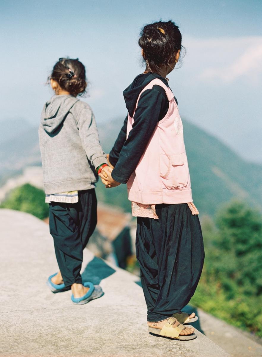 Two children standing on steps holding hands 