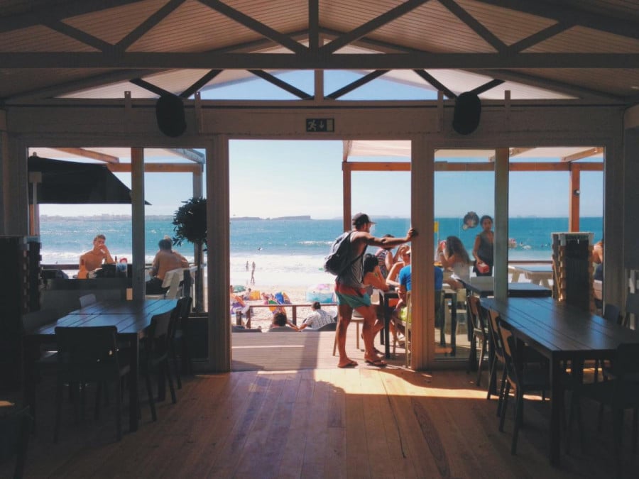 People sitting at a restaurant bar by the beach
