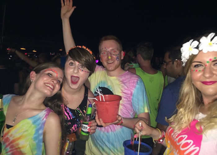 A group of face-painted travellers with drinks and thai buckets at a Full Moon Party