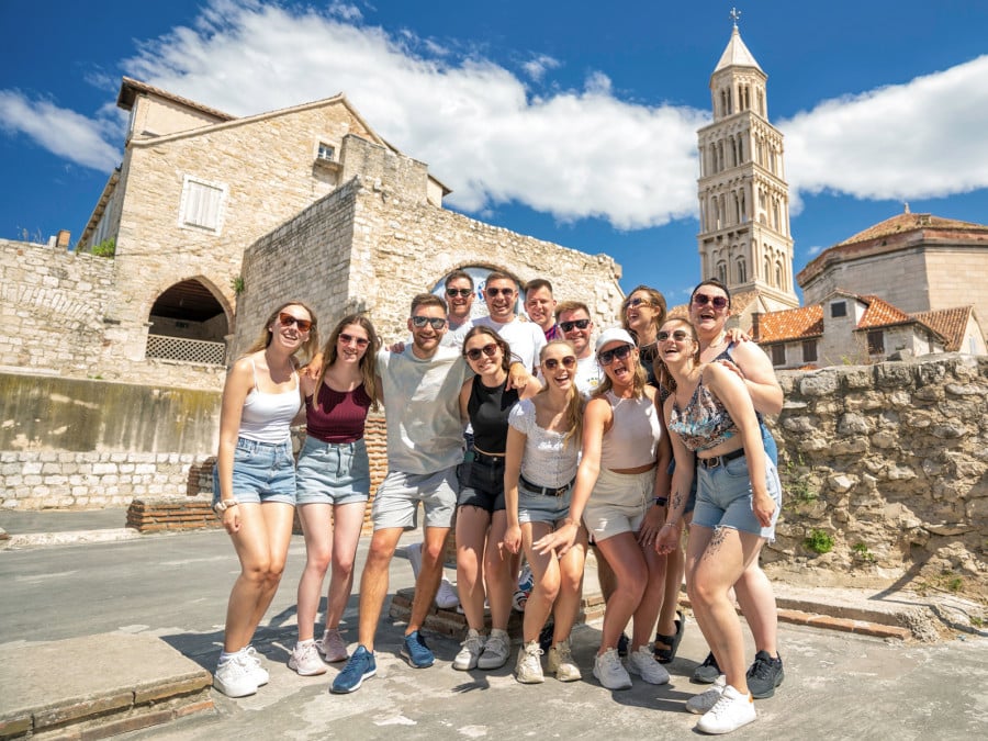 A group of travellers standing in front of buildings in Split, Croatia