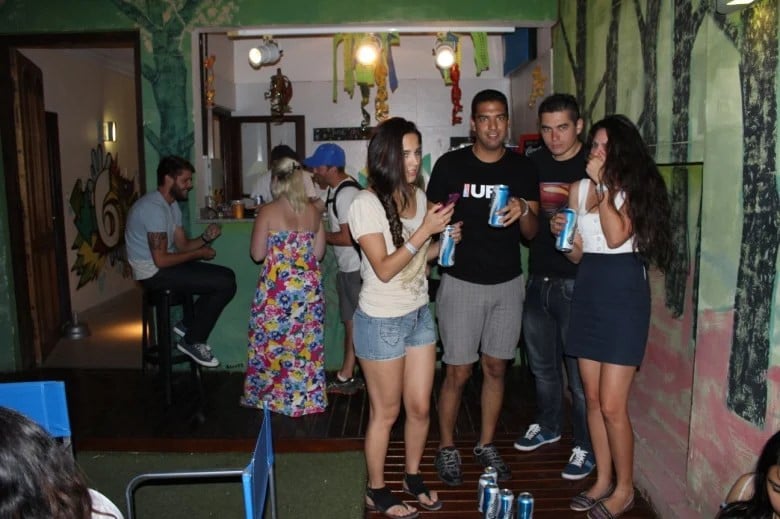 Travellers standing in a group at the hostel bar