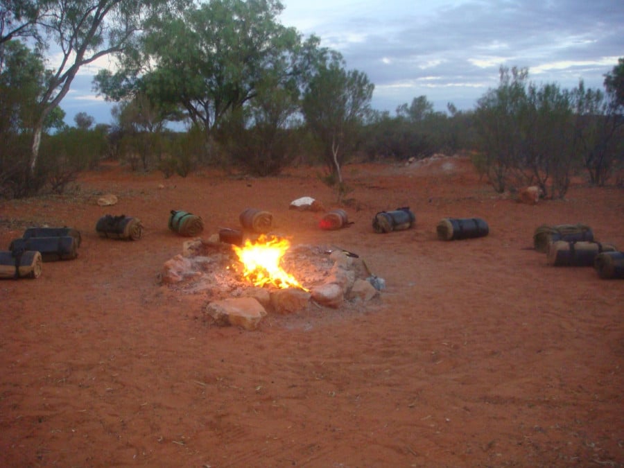 Swags lined up around a campfire