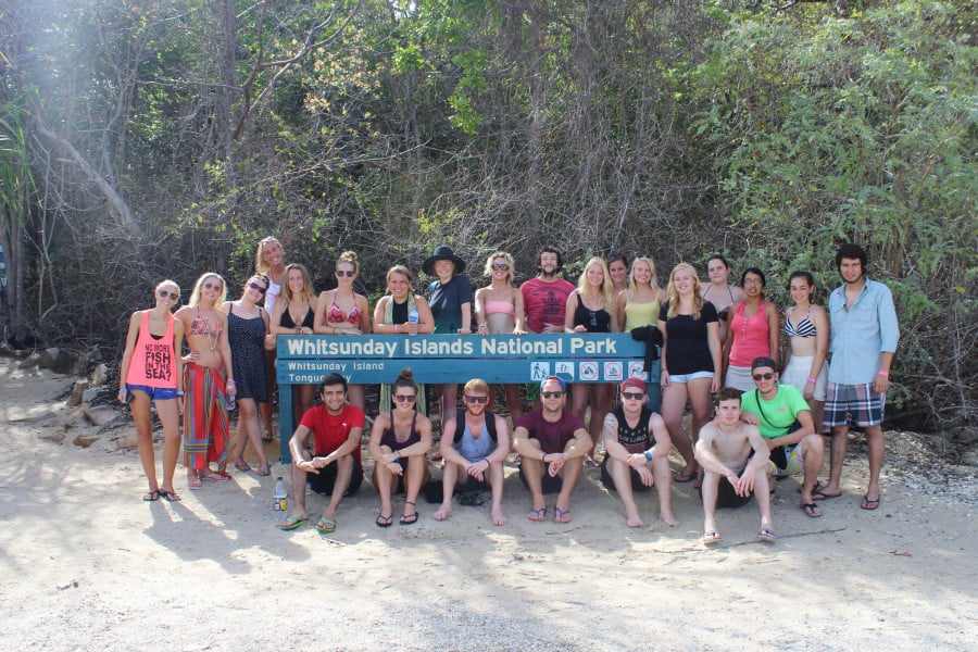 Georgia and a hroup of fellow travellers in front of a sign that reads 'Whitsunday Islands National Park'