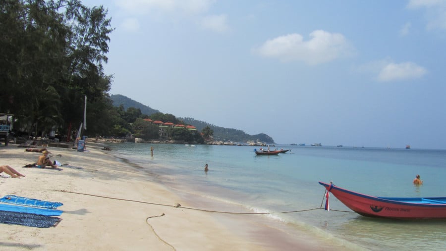 A Thailand beach with people and boats