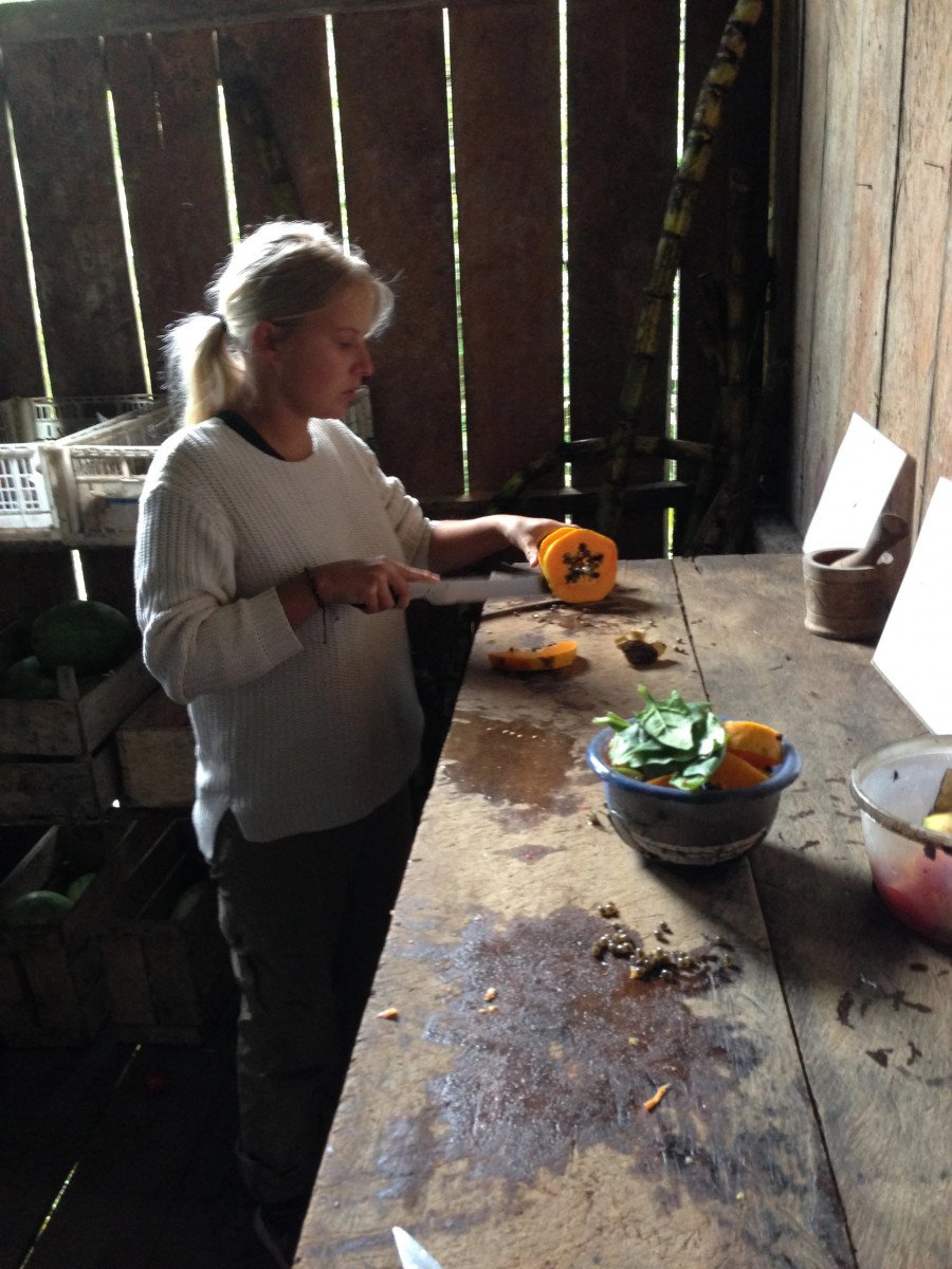 A lady cutting vegetables on a wooden table