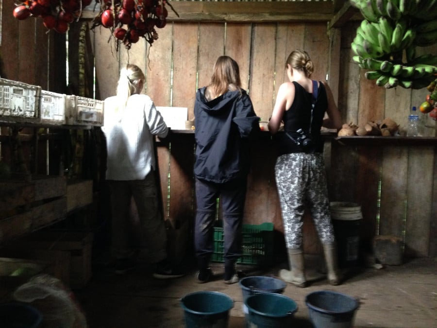 Three volunteers preparing food at their accommodation