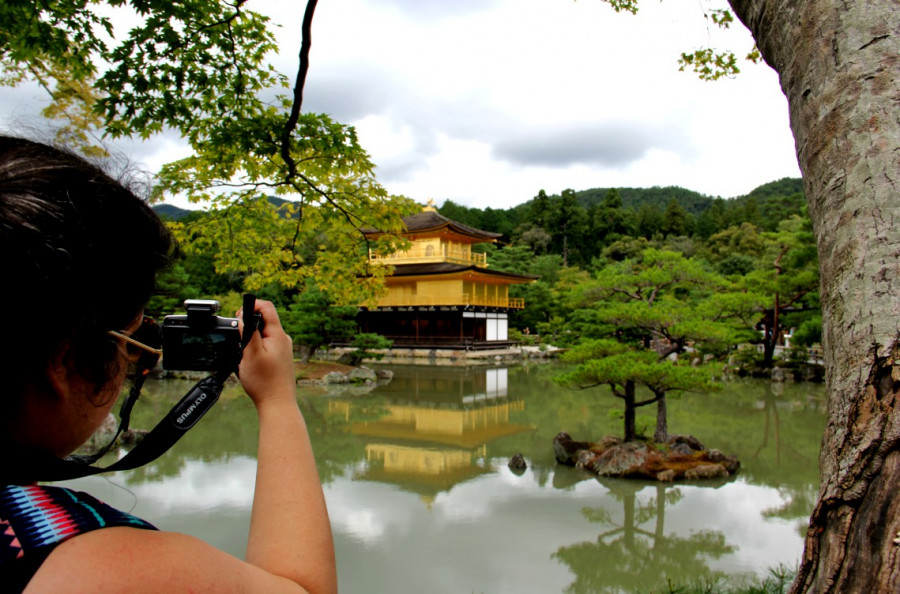 A lady photographing a Japanese temple