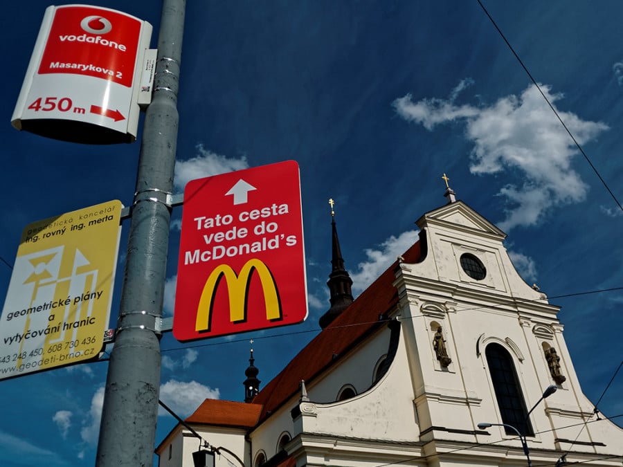 A sign in Spanish pointing to a Mcdonalds