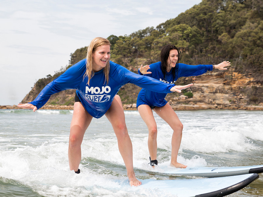 Two girls surfing a wave
