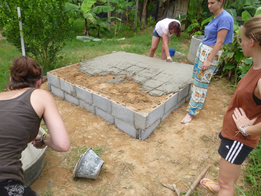 Volunteers laying concrete for a building