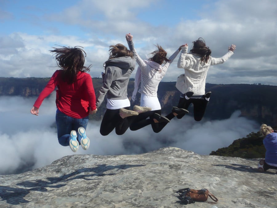 Travellers jumping in the air on a rock in the Blue Mountains