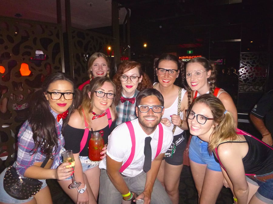 Travellers wearing costumes with glasses and drinking in a bar