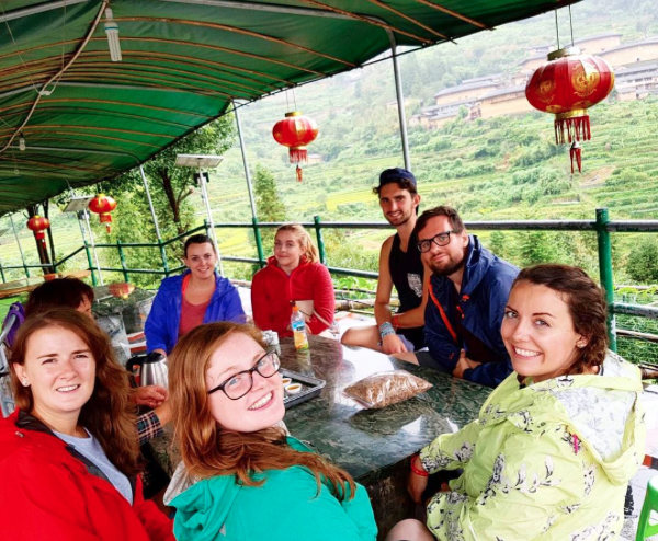 Travellers sitting in a restaurant with rice paddies in the background