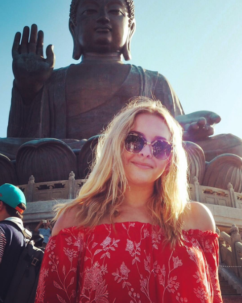 Georgia standing in front of a large Buddha statue