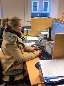 A Gap 360 staff member weating a coat and a scarf at her desk